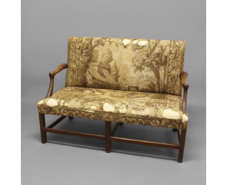 AN 18TH CENTURY WALNUT COUNTRY HOUSE SETTEE. with a tapestry seat and back depicting a rural scene, the scrolling arms with l