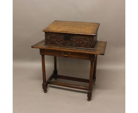 AN 18TH CENTURY OAK BIBLE BOX. the front and sides with foliate carving, set within a recess on a later oak table with single