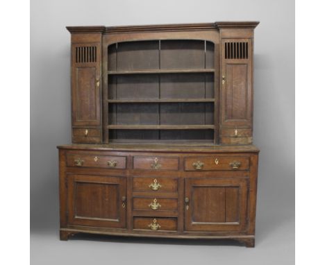 AN 18TH CENTURY OAK DRESSER. the top with three shelves flanked by cupboards above small drawers, the base with an arrangemen