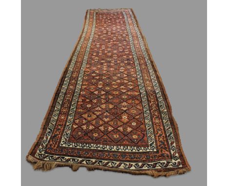A NORTH WEST PERSIAN RUNNER, CIRCA 1910. the chestnut diamond lattice field enclosed by triple narrow borders of meandering v