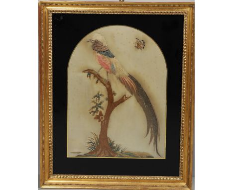 A 19TH CENTURY SILKWORK PICTURE. depicting an exotic bird on a branch with a butterfly above, in a black glass mount and gilt