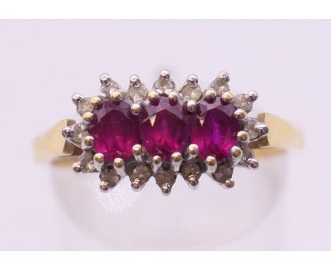 An 18 ct three-ruby and diamond ring. Ring size P/Q.