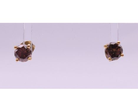 A pair of 18 k chocolate diamond stud earrings. Approximately 5 mm diameter.