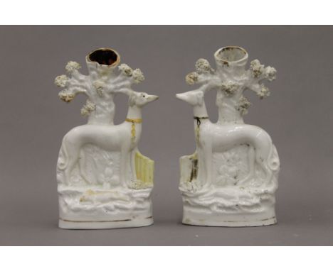 A pair of 19th century Staffordshire pottery spill vase figures of standing greyhounds wearing coursing collars, and with har