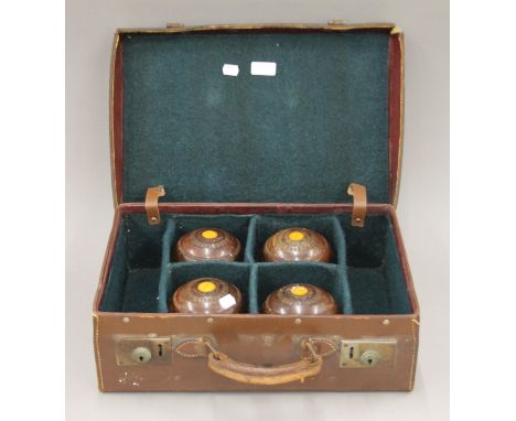 A vintage case containing four bowling woods. The case 45 cm wide.