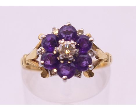 An 18 ct gold amethyst and diamond daisy cluster ring. Ring size M.