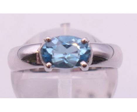 A platinum and aquamarine or topaz ring. Ring size K/L.