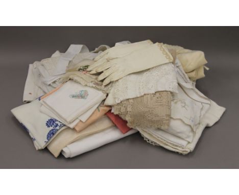 A quantity of vintage clothes, gloves, embroidered table linens etc.