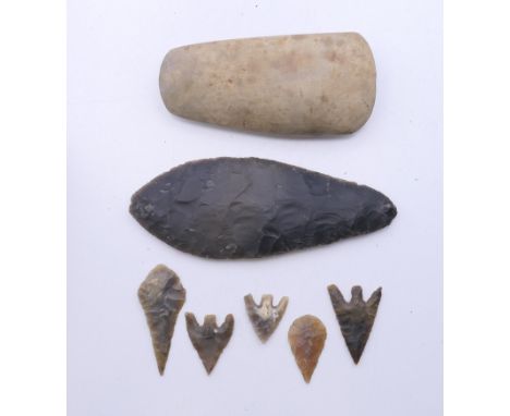 A polished stone axe head marked as having been found in Burwell Fen, Cambridgeshire and a knapped flint spear head and five 