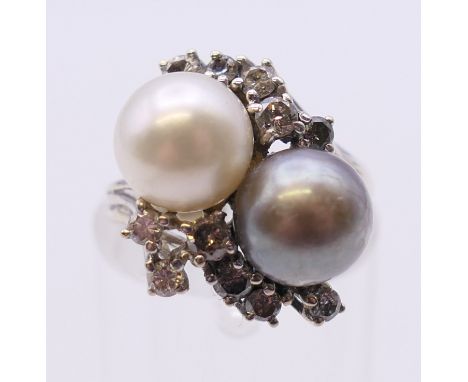 A 14 ct white gold black and white pearl and diamond ring. Ring size I.