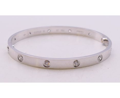 A boxed Cartier 18 ct white gold and diamond love bangle, numbered STA413. 7 cm wide. 37.4 grammes total weight. 