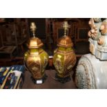 A pair of gilt decorated table lamps raised on woo