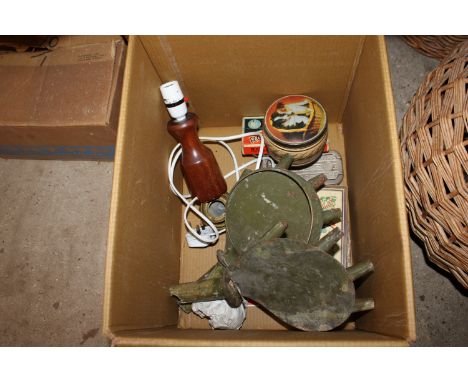 A box containing wooden table lamp, advertising tins etc.