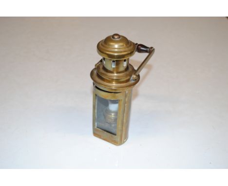 A brass handheld lamp with swing handle