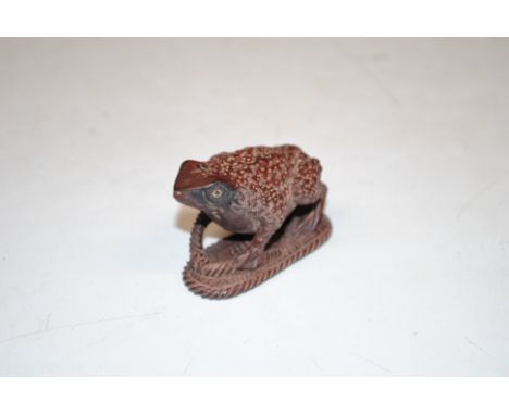 A wooden Netsuke in the form of a frog