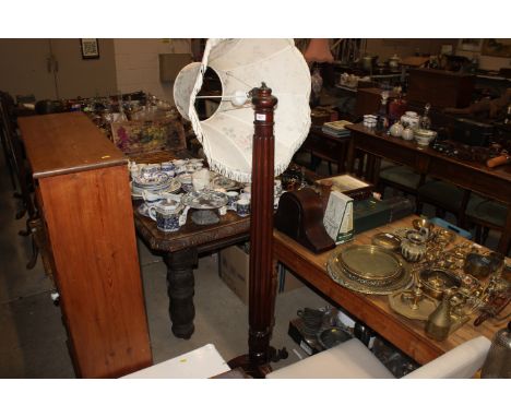 A carved mahogany standard lamp and shade, raised on tripod ball and claw supports, AF