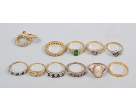 Ten assorted rings and a pair of hoop earrings, to include an emerald ring with baguette cut diamonds to shoulders, a diamond