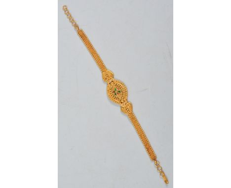 A yellow metal filigree bracelet and similar earrings, the bracelet having an enamel motif to centre, the earrings for pierce