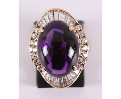 A 14 kt 585/1000 gold ring with a cabochon cut amethyst, flanked by baguette and brilliant cut zirconias. Ring size 17.75 mm.