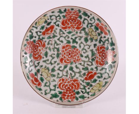 A porcelain famille verte dish, China, Kangxi, 18th century. Polychrome decor of peonies, Ø 22 cm (2x hairline/crack)