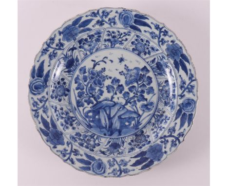 A blue/white porcelain contoured dish, China, Kangxi, around 1700. Blue underglaze decor of chrysanthemums on a rock and inse