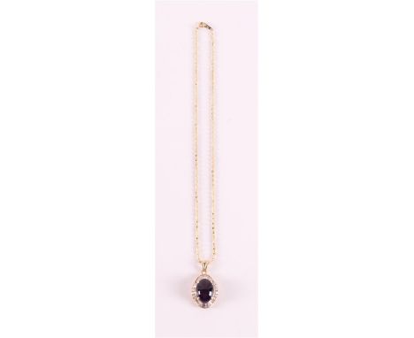 A 14 kt 585/1000 gold necklace and pendant with a cabochon cut amethyst flanked by baguette and brilliant cut zirconias.