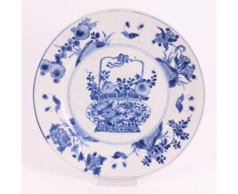 A blue/white porcelain deep plate, China, Kangxi, around 1700. Blue underglaze decor of a flower basket on the shelf, the lip