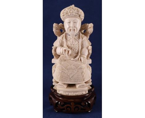 A carved ivory seated emperor, China, Guangxu (1875-1908), ca. 1910, signed on the bottom, weight 745 grams, h 21.5 cm (inclu