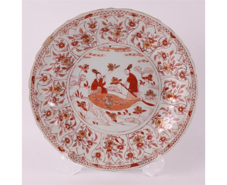 A porcelain milk and blood 'Rouge de fer' contoured dish, China, Kangxi, around 1700. Decor of women in a garden on the shelf