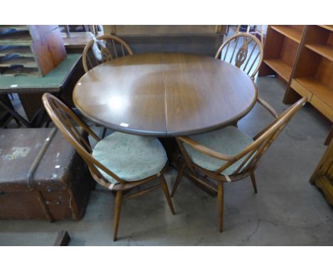 An Ercol circular extending pedestal dining table and four chairs