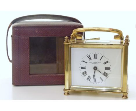 A French-made brass carriage clock. The white enamel dial has Roman numerals and bears the retailers mark 'Page Keen & Page, 