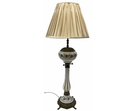 Table lamp in the form of a Victorian oil lamp, the cast metal base with four lion mask and paw feet, leading to a milk glass