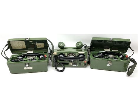Three field telephones, with rotary dials, in hard plastic cases, one missing its cover, all with canvas straps, together wit
