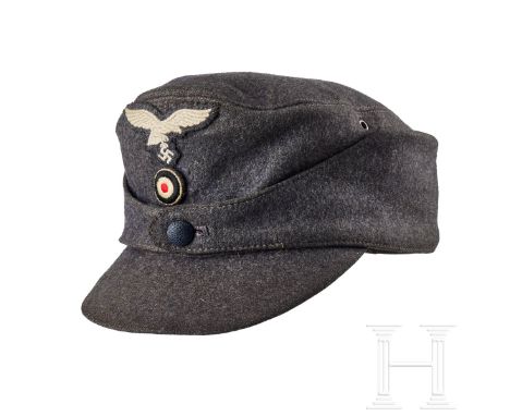 A Field Cap for Other Ranks  Cap body in blue-grey wool, turn-up ear/neck flap with single blue-grey finished pebbled button 