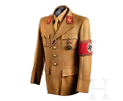 A Political Leader Tunic  Light-brown fine tricot wool, open collar piped in dark red, scalloped and pleated pockets, four-bu