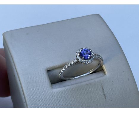 A 9ct white gold tanzanite and diamond halo design ring, M.