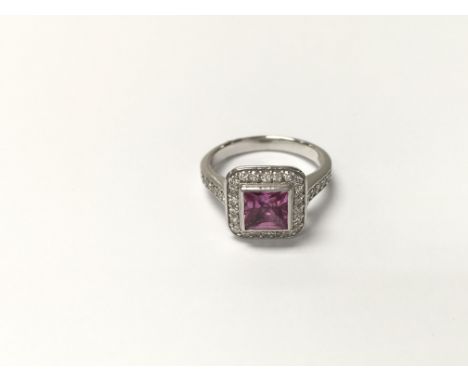 An 18ct white gold ring set a central pink tourmaline and surrounded and shouldered by small diamonds. The approximate ring s