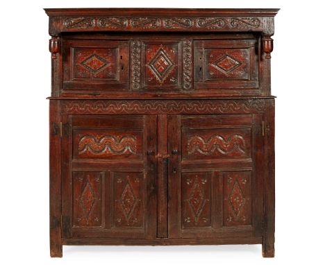 OAK COURT CUPBOARD 17TH CENTURY the moulded cornice above a scroll carved frieze, over a pair of doors with lozenge carved pa