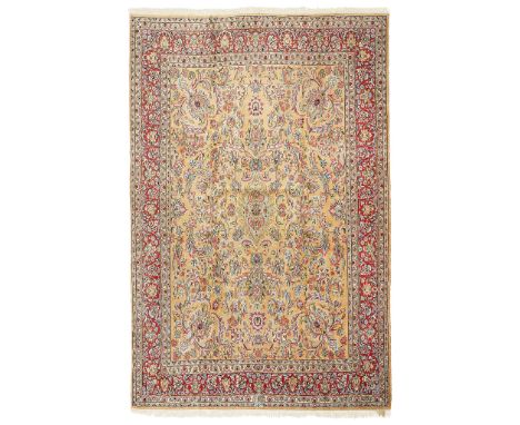 KIRMAN CARPET CENTRAL PERSIA, 20TH CENTURY the light brown field with small blue elongated medallion surrounded by foliate pa