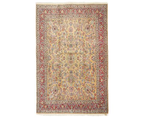 KIRMAN CARPET CENTRAL PERSIA, 20TH CENTURY the light brown field with small blue elongated medallion surrounded by foliate pa