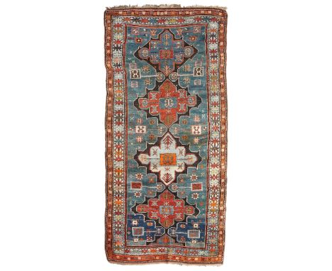 KAZAK LONG RUG SOUTH CAUCASUS, LATE 19TH/EARLY 20TH CENTURY the abrash turquoise field with four red and blue lozenge medalli