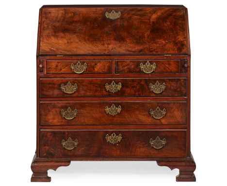 GEORGE II WALNUT BUREAU EARLY 18TH CENTURY the slant front opening to an arrangement of drawers and pigeon holes, over two sh