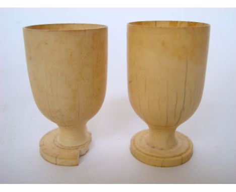 A pair of 19th Century ivory egg cups, one a/f with losses to foot. 