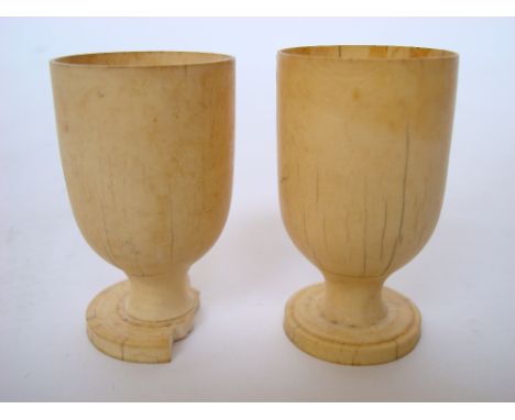 A pair of 19th Century ivory egg cups, one a/f with losses to foot. 