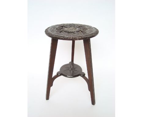 A late Victorian ebonised carved oak occasional table, on tripod base with platform stretcher.
58cm h. 