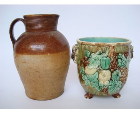 A large saltglazed stoneware flagon and a majolica glazed planter moulded with goats masks to either side and fruit on paw fe