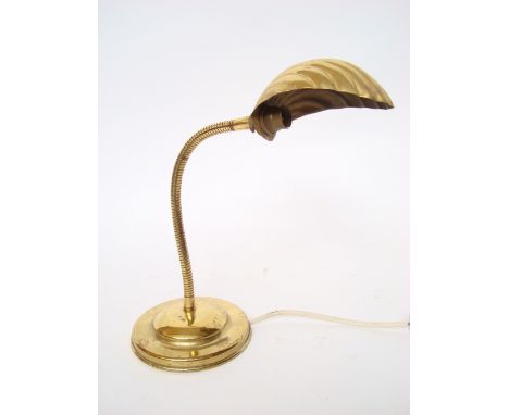 A brass desk light with scallop shell shade on articulated stem.  