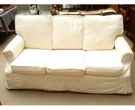 A two seater style sofa bed, upholstered in yellow material, with Plumbs cream loose covers. 