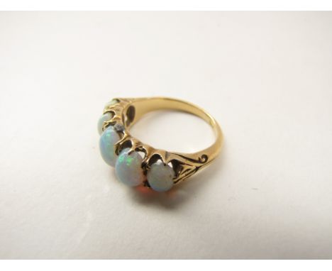 An opal five stone ring, the five graduated stones claw set, in 18 ct. gold with carved shanks, ring size I 1/2. 