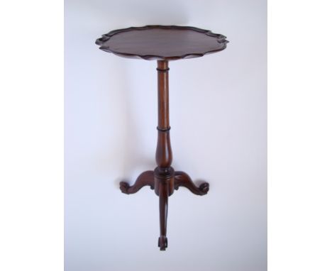 A Mahogany wine table with pie-crust edge raised on tripod base.